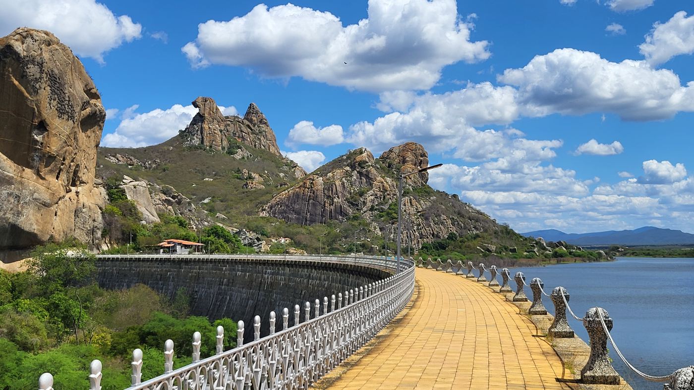 Walkway along the Açude do Cedro dam, granite monoliths behind
