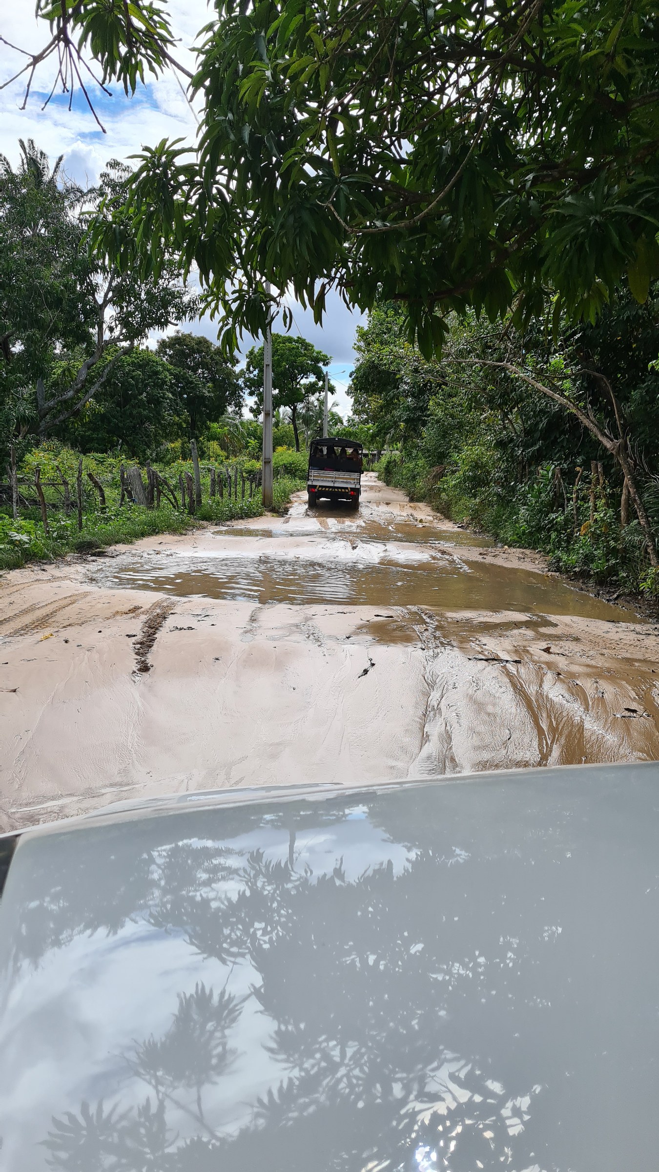 A 4x4 vehicle driving along a flooded, muddy dirt road between São Luís and Barreirinhas during the rainy season